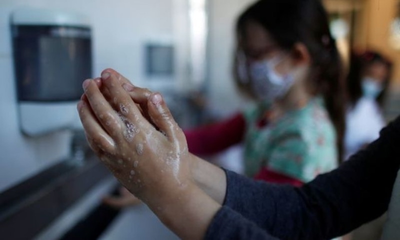 Schoolchildren clean their hands at the private primary school Jeanne D'Arc in Saint-Maur-des-Fosses, near Paris, amid the Covid-19 outbreak in France, March 30. — Reuters