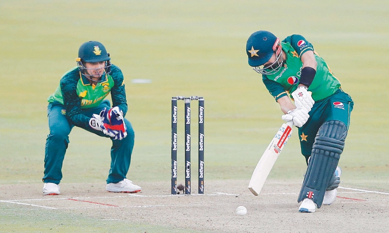 CENTURION: Pakistan captain Babar Azam drives during his innings of 103 as South African wicket-keeper Quinton de Kock looks on during the first One-day International at the SuperSport on Friday.—AFP CENTURION: Pakistan captain Babar Azam drives during his innings of 103 as South African wicket-keeper Quinton de Kock looks on during the first One-day International at the SuperSport on Friday.—AFP