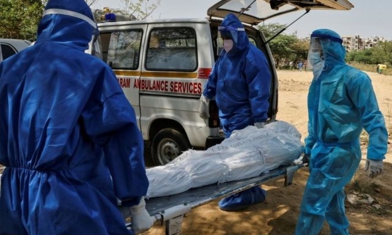 Health workers carry the body of a man who died from Covid-19, for burial at a graveyard in New Delhi, India, April 9. — Reuters
