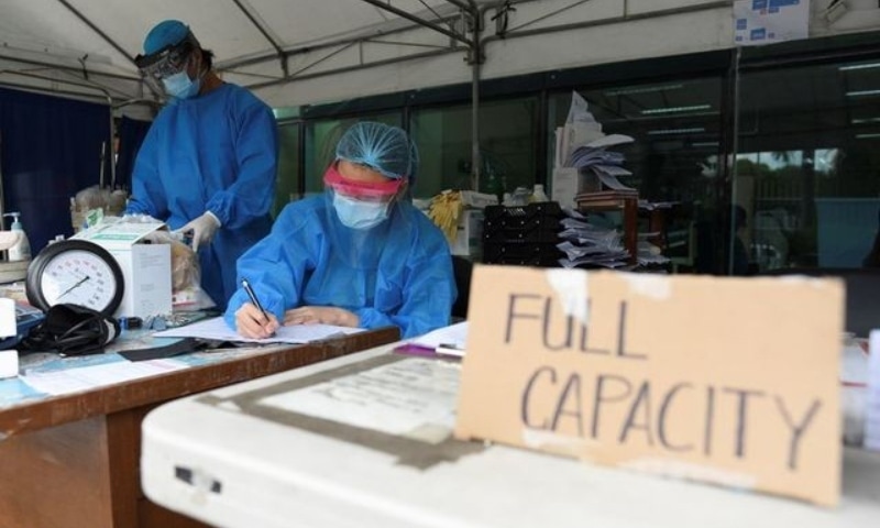 Health workers sort patients' files at a triage area in Santa Ana Hospital, where a sign indicating that the hospital's Covid-19 facility is at full capacity is displayed, in Manila, Philippines, April 9. — Reuters