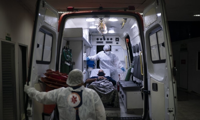 Mobile emergency care service workers move a Covid-19 patient to an ambulance as he is transferred to a municipal hospital dedicated to Covid-19 in Duque de Caxias, Rio de Janeiro state, Brazil, April 6. &mdash; AP