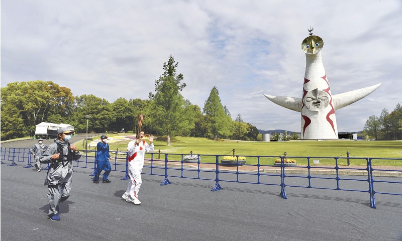 FORMER Japanese swimmer Aya Terakawa carries the Tokyo 2020 Olympic torch during the relay at the Expo &lsquo;70 Commemorative Park in Suita on Tuesday.&mdash;AFP