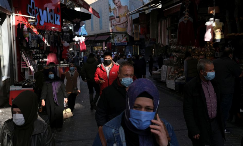 People wearing protective face masks, walk at a popular middle-class shopping district in Turkey. — Reuters