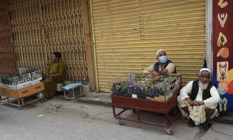 Vendors selling wristwatches sit along a closed market after a lockdown was imposed as a preventive measure against the spread of the coronavirus in Quetta on Saturday. &mdash; AFP