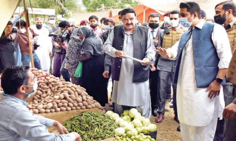 Interior Minister Sheikh Rashid Ahmed being briefed on the rate list during his visit to a Sasta bazaar in G-7 on Sunday. — Online