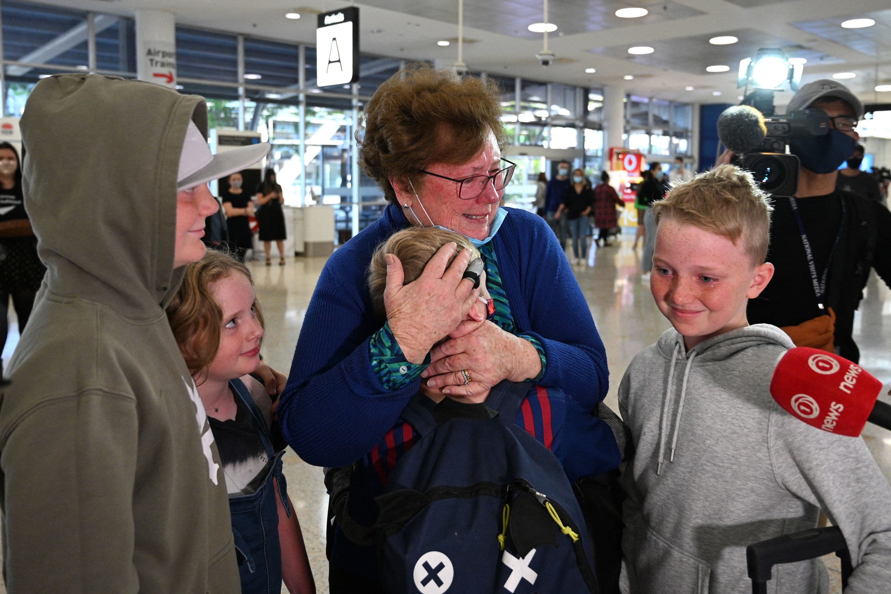A woman hugs her family members upon their arrival from New Zealand at Sydney International Airport on April 19. &mdash; AFP