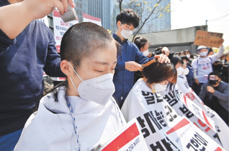 South Korean protesters have their heads shaved during a protest in front of the Japanese embassy on Tuesday against Tokyo’s decision to release treated water from the stricken Fukushima Daiichi nuclear plant into the sea.—AFP