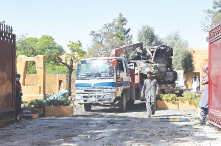 A TRUCK transports damaged vehicles from Serena Hotel, a day after a deadly suicide blast struck the building, on Thursday.—AFP