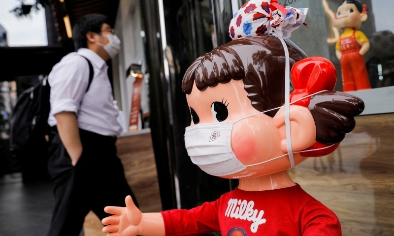 A mannequin known as 'Peko-chan' wearing a protective mask is displayed at Fujiya store in Tokyo on April 22. &mdash; AFP