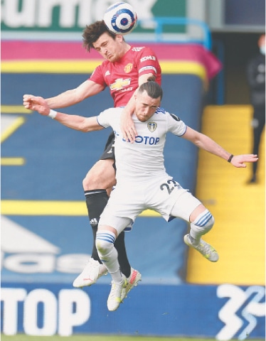 LEEDS: Manchester United’s Harry Maguire (top) vies for the ball with Leeds United’s Jack Harrison during their Premier League match at Elland Road on Sunday.—Reuters