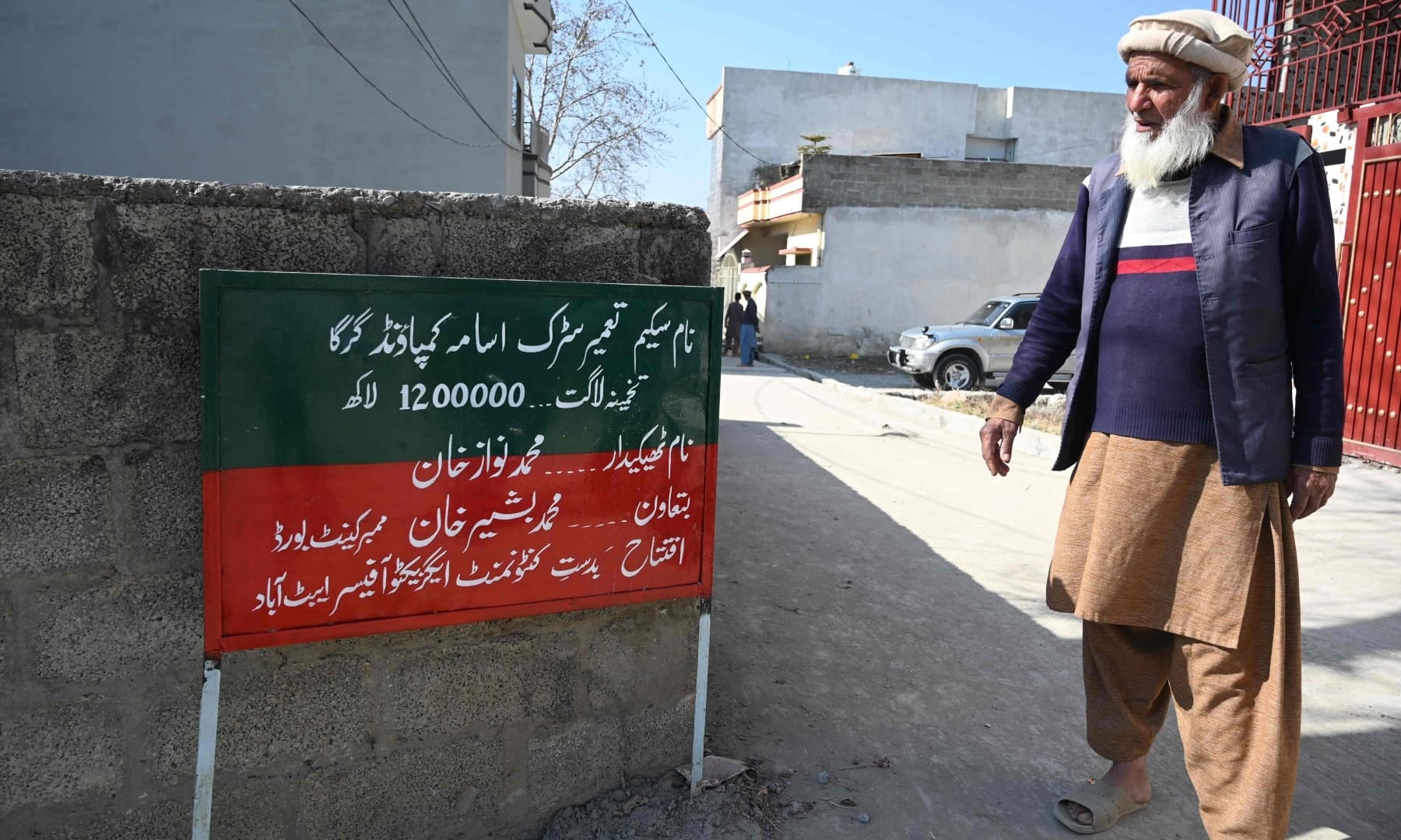 Local resident Altaf Hussain and neighbour of Osama bin Laden stands next to a signboard at the site of the demolished compound of Bin Laden in northern Abbottabad, in this picture taken on February 11, 2021. — AFP