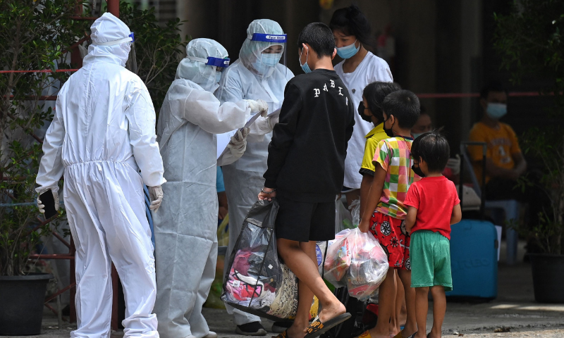 Health workers attend to people arriving at the Wat Saphan temple converted as an isolation centre for coronavirus patients in Bangkok. — AFP