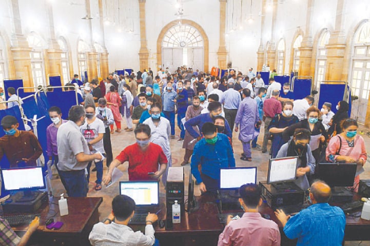 People queue up to register to be inoculated with a dose of Sinopharm at a vaccination centre in Karachi on Wednesday.—AFP