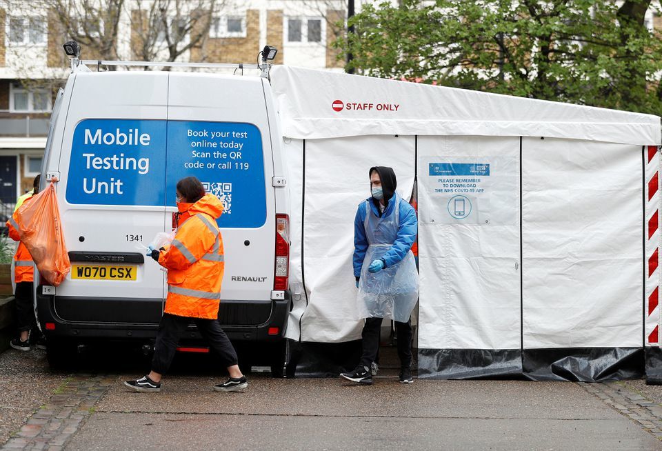 NHS workers are seen next to a Covid-19 mobile testing unit in Tower Hamlets, London, Britain, May 2. — Reuters