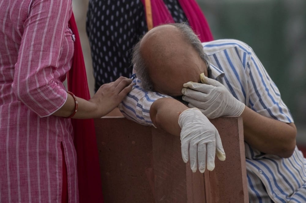 A man reacts before the cremation of his relative, who died from the coronavirus disease on the banks of the river Ganges on May 6. — Reuters