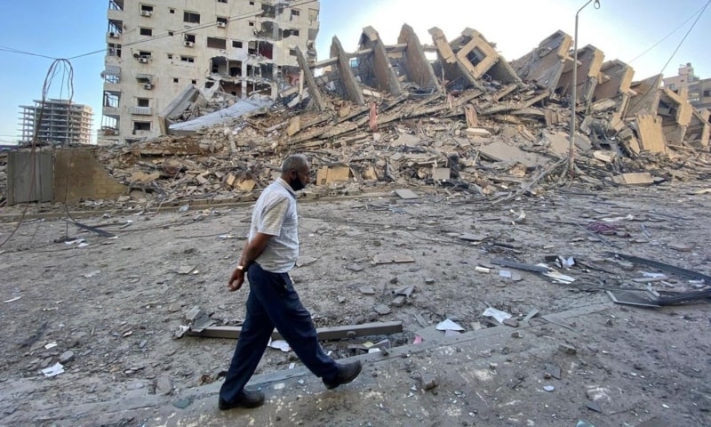 A Palestinian man walks past a tower building which was destroyed in Israeli air strikes, amid a flare-up of Israeli-Palestinian violence, in Gaza City, May 12. — Reuters