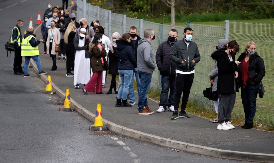 People line up outside a mobile vaccination centre in Bolton, Britain, May 13. — Reuters