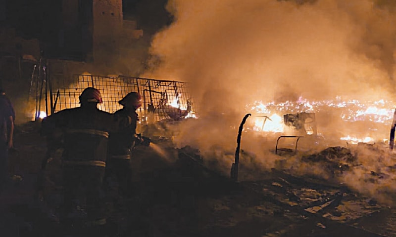 RAHIM YAR KHAN: Firefighters extinguish the flames that ravaged shops at Lunda Bazaar. &mdash; Dawn