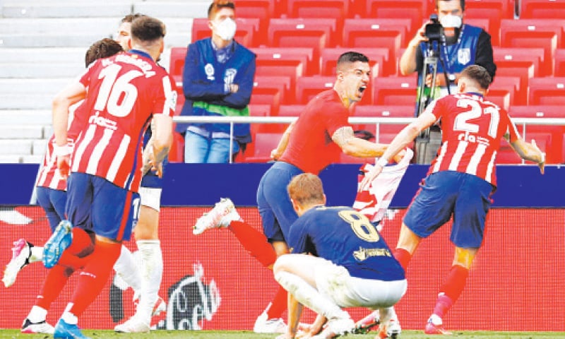 MADRID: Atletico Madrid’s Luis Suarez (C) celebrates with team-mates after scoring the late winner during the La Liga match against Osasuna at the Wanda Metropolitano Stadium.—Reuters