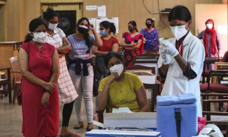 An Indian nurse prepares to administer a dose of Covishield, Serum Institute of India’s version of the AstraZeneca vaccine to a woman as others wait their turn in Bengaluru, India, May 19. — AP