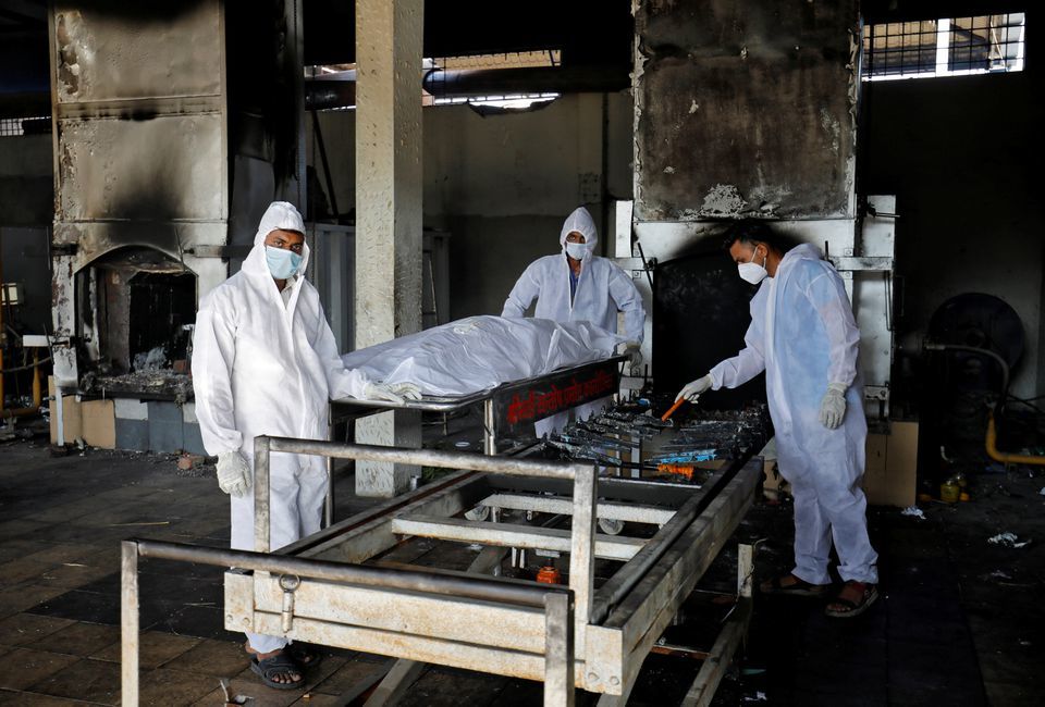 Volunteers from the Khan Trust prepare to cremate the body of a person who died from Covid-19, at the Kurukshetra Crematorium in Surat, India, May 11. &mdash; Reuters