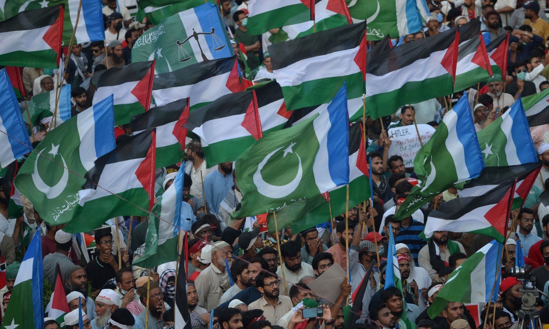 Supporters of the Jamaat-e-Islami (JI) wave Palestinian and their party flags during a protest against Israel's attacks on the Palestinian Gaza Strip in Karachi on May 23. — AFP