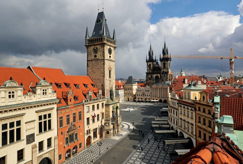 A clock showing the time at noon is pictured on a building, next to almost empty streets at Old Town Square, Prague, Czech Republic, March 31. — Reuters