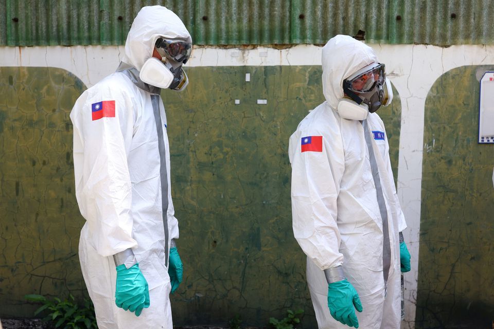 Soldiers wear protective suits as they disinfect a street following the recent surge of coronavirus infections, in Tucheng district of New Taipei City, Taiwan, May 27. &mdash; Reuters