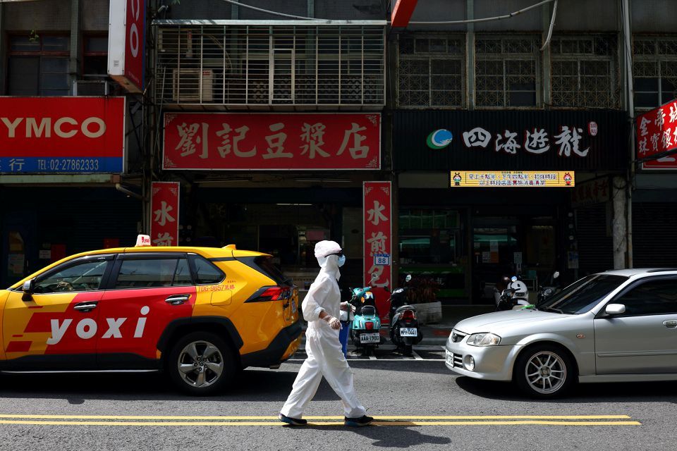A person dressed in protective suit walks down a street following the recent surge of coronavirus  infections in Taipei, Taiwan, June 2. &mdash; Reuters