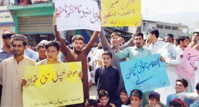 Protesters hold placards at a demonstration in Timergara on Friday. &mdash; Dawn