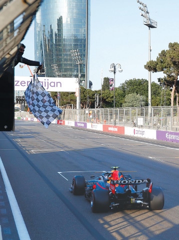 BAKU: The checkered flag waves for Red Bull’s Sergio Perez of Mexico as he crosses the finish line to win the F1 Grand Prix at the Baku Formula One city circuit on Sunday.—Reuters