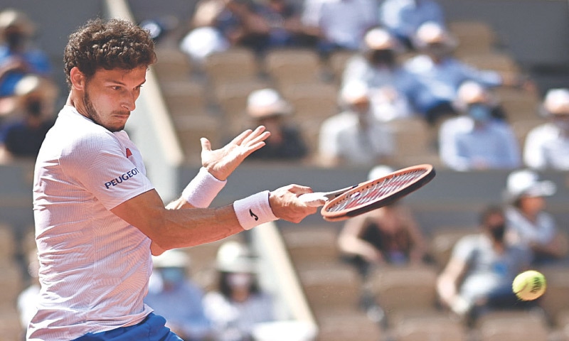 PABLO Carreno Busta of Spain returns the ball to Greece’s Stefanos Tsitsipas during their men’s singles fourth-round match at the Roland Garros on Sunday.—AFP