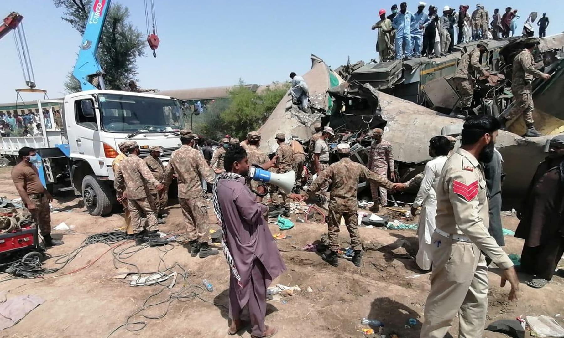 Paramilitary soldiers and rescue workers gather at the site of a collision between two trains in Ghotki, June 7. — ISPR via Reuters