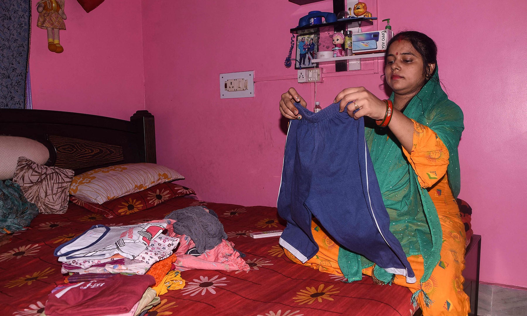 In this picture taken on June 4, 2021 Kumari Kajal, who is in her eighth month of pregnancy, folds clothes at her home in Muzaffarpur city in the eastern state of Bihar. — AFP