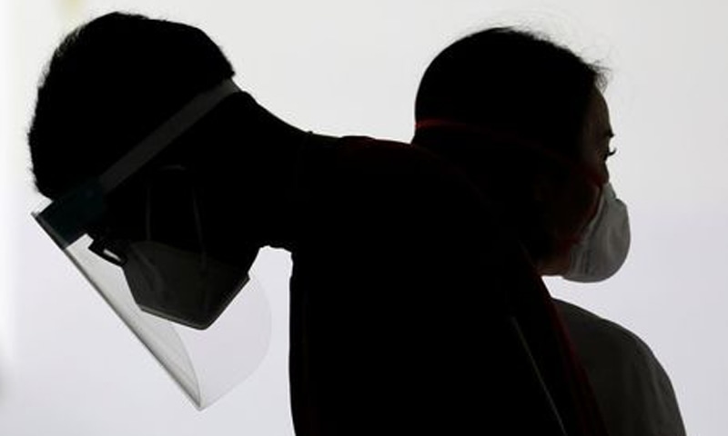 Healthcare workers wait to assist residents for their mandatory Covid-19 swab tests after some residents were tested positive for the virus, at a public housing estate in Singapore. &mdash; Reuters