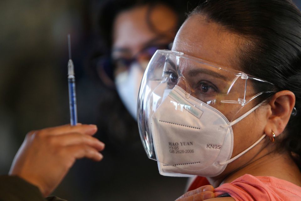 A teacher looks at a dose of China's CanSino Covid-19 vaccine during a mass vaccination for teachers and school staff in Mexico City, Mexico, May 18. — Reuters