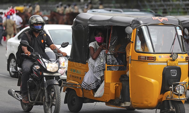 People wearing face masks as a precaution against the coronavirus move on a street in Hyderabad, India on Wednesday. — AP