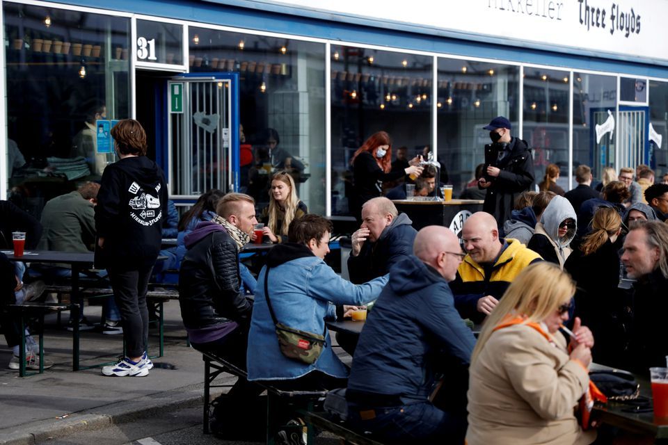 Customers sit outside a bar as a Covid-19 lockdown has been partially lifted in central Copenhagen, Denmark, April 23. — Reuters