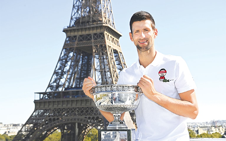 PARIS: Serbia’s Novak Djokovic poses with the French Open trophy in front of the Eiffel tower during a photocall on Monday.—AP