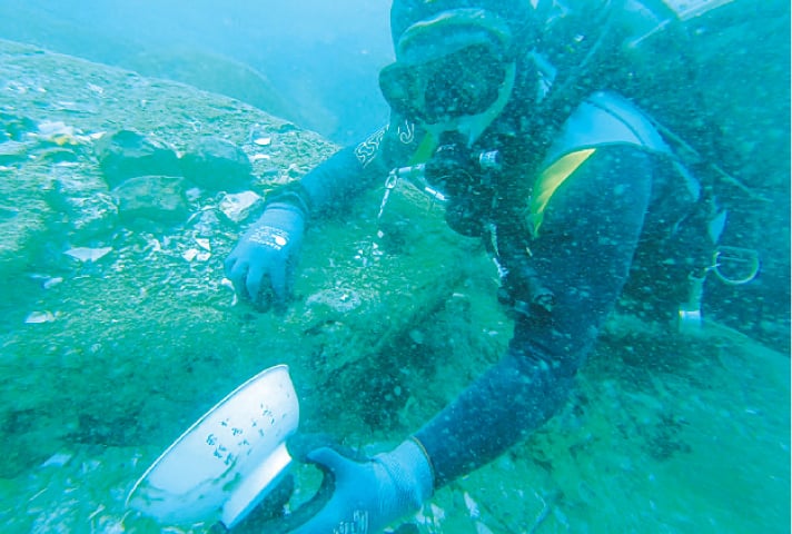 A DIVER holding a bowl with Chinese characters that was discovered from the shipwreck.—AFP