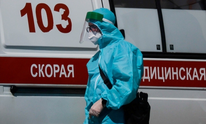 A medical specialist walks by an ambulance outside a hospital for patients infected with the coronavirus in Moscow on June 16. — Reuters