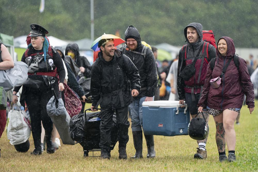 Festivalgoers arrive during a downpour on the first day of Download Festival at Donington Park at Castle Donington, England, June 18. — AP