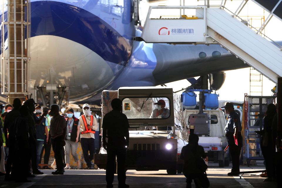 Workers transport Moderna vaccines to Taiwan Air cargo Terminal in Taoyuan, Taiwan, June 18. — Reuters