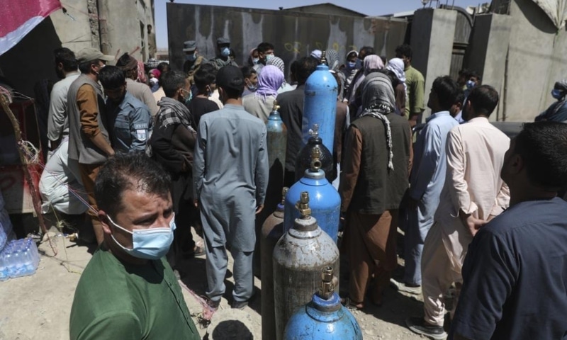 Men wait outside a privately owned oxygen factory to get their oxygen cylinders refilled, in Kabul, Afghanistan, June 19. — AP