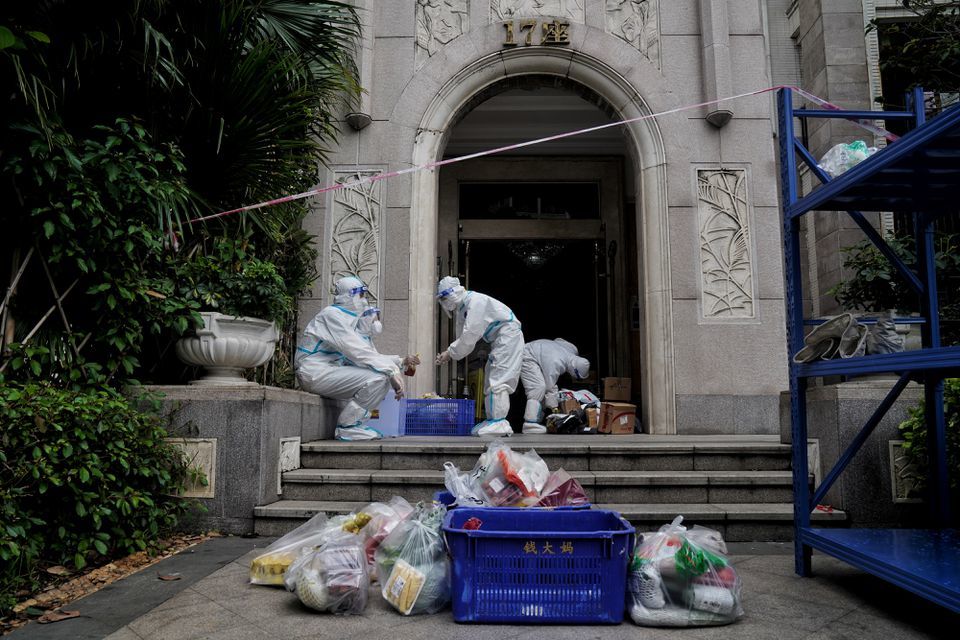 Property management workers in protective suits deliver goods to residents at a compound under lockdown due to the recent coronavirus outbreak in Guangzhou, Guangdong province, China, June 2. &mdash; Reuters