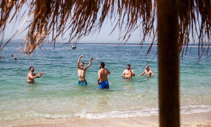 People enjoy the sea near Athens, Greece, during the official reopening of beaches to the public following the easing of measures against the spread of Covid-19, on May 8. &mdash; Reuters