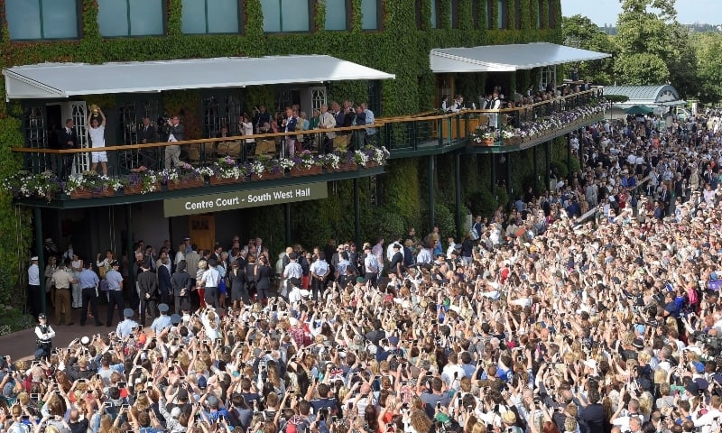 Britain's Andy Murray holds aloft the trophy on the balcony outside Centre Court after winning the 2016 Wimbledon men's singles final against Canada's Milos Raonic. — Reuters