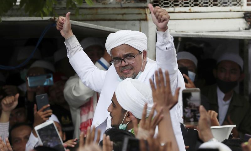 In this file photo, Indonesian cleric Rizieq Shihab gestures to his followers as he arrives from Saudi Arabia in Jakarta, Indonesia. — AP