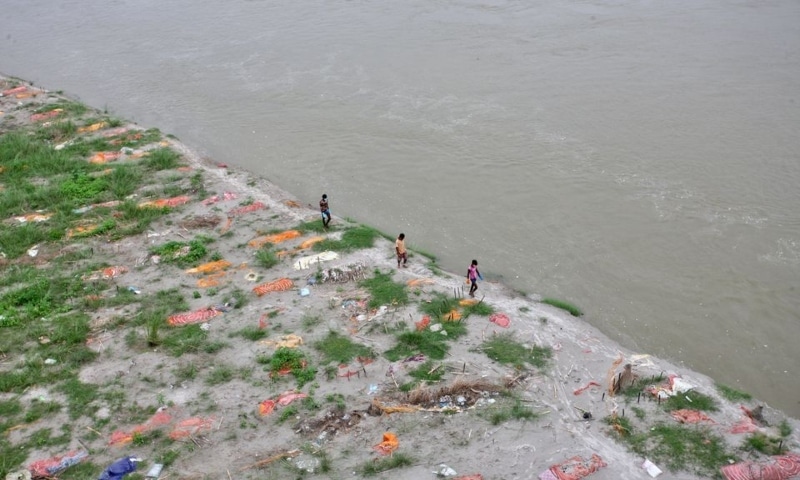 Municipal workers search for bodies along the Ganges riverbank after monsoon rains swelled up the river and exposed bodies buried in shallow sand graves during the peak of the latest wave of Covid-19 in Phaphamau, Prayagraj, India, June 25. — Reuters Municipal workers search for bodies along the Ganges riverbank after monsoon rains swelled up the river and exposed bodies buried in shallow sand graves during the peak of the latest wave of Covid-19 in Phaphamau, Prayagraj, India, June 25. — Reuters