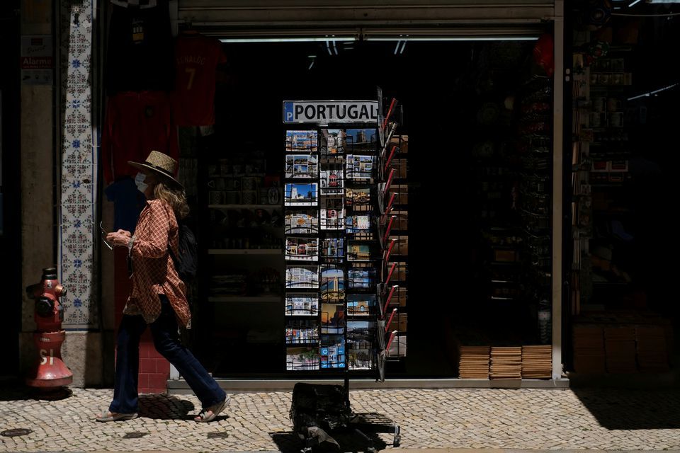 A woman wearing a protective mask walks in Lisbon downtown, Portugal, June 24. &mdash; Reuters